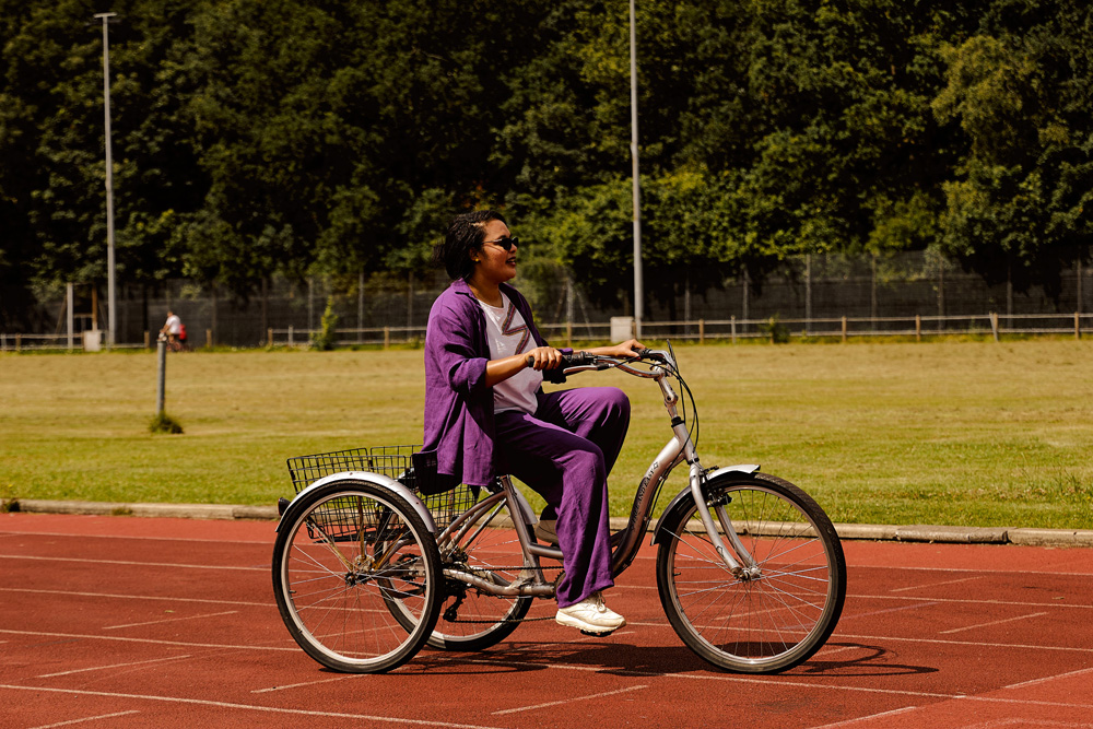 A person riding a trike (bicycle but with three wheels)